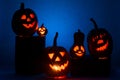 Five Halloween pumpkins, merry faces on a blue background. Royalty Free Stock Photo