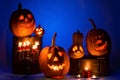 Five Halloween pumpkins, merry faces on a blue background. Royalty Free Stock Photo