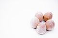 Five hand-made unpainted wooden eggs on a white background