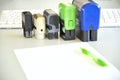 Five handle automatic stamps, sheet of paper and pen on a desk