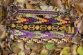 Five handmade homemade colorful natural woven bracelets of friendship in autumn dry leaves, fall color Royalty Free Stock Photo