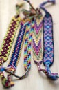 Five handmade homemade colorful natural woven bracelets of friendship on wooden board, group of fashion accessories