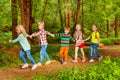 Five happy kids walking in forest holding hands Royalty Free Stock Photo