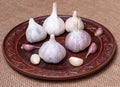 Five heads of garlic on a clay plate.Five cloves of garlic.