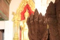 Five heads of stucco Naga or dragon with out focus brass buddha statue. Royalty Free Stock Photo