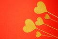 Five hearts of yellow on a red background. View from above. Hearts are on the right. Concussion is love. Valentine is Day. Romance