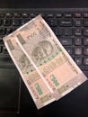Five hundred rupees Indian currency notes on a laptop keyboard