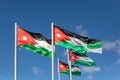 Five Jordanian flags flying briskly on a sunny day