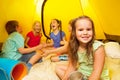 Five kids sit inside a yellow tent