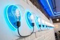 Five light blue neon bulbs on white wall with glowing blue neon lights. Texture background Royalty Free Stock Photo