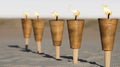 Five Lit Bamboo Torches on Sandy Beach Royalty Free Stock Photo