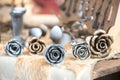 Five metal roses of silver and gold color on the table at the seasonal fair of masters