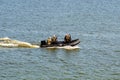 Five military men with weapons and special equipment in the black motor boat. Special operations forces