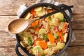 Five-minute potatoes with bacon, onions and carrots close-up in a frying pan. horizontal top view Royalty Free Stock Photo