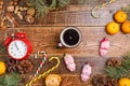 Five minutes before the New Year and a cup of coffee. Cozy wooden background Christmas sweets and toys pigs.