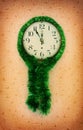 At five minutes to twelve on the old wall clock decorated with green tinsel Royalty Free Stock Photo