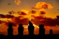Five moais at Easter Island against orange and red sunset