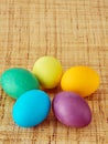 Five multi colored painted eggs on wooden background. Happy Easter concept, copy space. Royalty Free Stock Photo