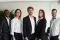 Five multi-ethnic millennial professionals posing at workplace Royalty Free Stock Photo