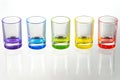 Five multicolored empty shot glasses placed symmetrically on a w Royalty Free Stock Photo