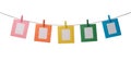 Five multicolored paper photo frames hanging on the rope with wooden clothespins isolated on white Royalty Free Stock Photo