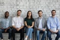 Five multiethnic applicants wait job interview smiling looking at camera