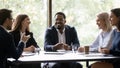 Five multiethnic company staff gather together talking planning future project Royalty Free Stock Photo