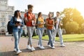 Five multiethnic students chatting and laughing while walking together at university campus Royalty Free Stock Photo