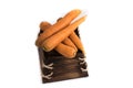 Five orange carrots rest on a small, rectangular wooden box.