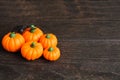 Five orange fake pumpkins with black spider on wooden table Royalty Free Stock Photo