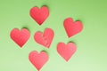 Five paper hearts surrounding one '' broken, lonely, down '' Green background Royalty Free Stock Photo