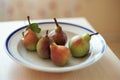 Five pears in a plate on a table Royalty Free Stock Photo
