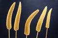 Five pickled corn on a fork close-up on a dark blue background. food and vegetables