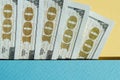 Five pieces of 100 dollar bills on the yellow and blue background. Conceptual photo, minimalistic design of United Royalty Free Stock Photo