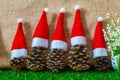 Five pine cones in a red Santa hats like a Christmas tree on a wooden background Royalty Free Stock Photo