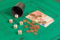 Five poker dices of ases, kings, banknotes, coins and beaker on