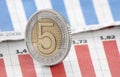 Five Polish Zloty coin on newspaper chart