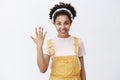 Five reasons to say yes. Portrait of good-looking happy and relaxed young African American girl in yellow dungarees and Royalty Free Stock Photo