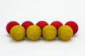 Five red and four yellow Christmas baubles, lies in a row isolated on a white background with a clipping path and copy space, chri Royalty Free Stock Photo