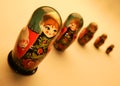 FIVE RED AND GREEN PAINTED RUSSIAN DOLLS ON YELLOW BACKGROUND