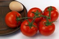 Five red ripe tomatoes and an egg Royalty Free Stock Photo