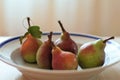 Five ripe pears in a plate on a table Royalty Free Stock Photo