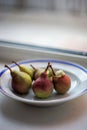 Five ripe pears in a plate on the windowsill Royalty Free Stock Photo