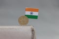 Five Rupee money coin of India and mini Indian flag stick on the leather wallet on grey background