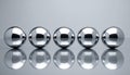 Five Shiny Silver Spheres on Reflective Surface Royalty Free Stock Photo