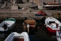 five small boats docked on a harbor near an old stone building Royalty Free Stock Photo