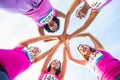 Five smiling runners supporting breast cancer marathon