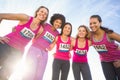 Five smiling runners supporting breast cancer marathon