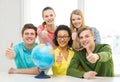 Five smiling student with earth globe at school