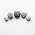 Five smooth pebbles arranged in a line against a white background Royalty Free Stock Photo